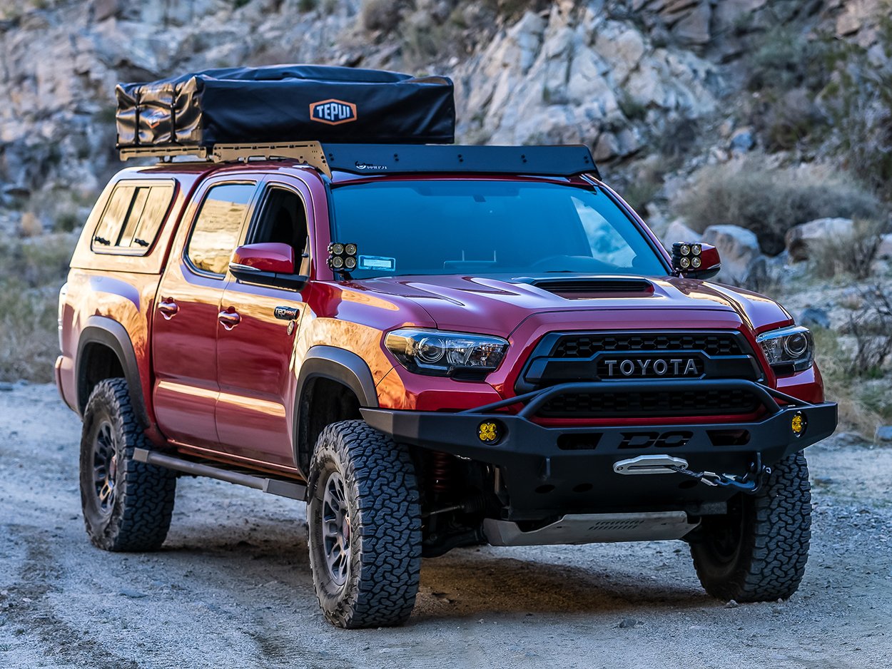 Lifted Barcelona Red Metallic Tacoma with Demello Front Bumper and Snugtop Camper Shell