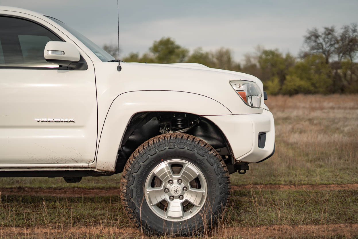 White Toyota Tacoma on a 3" Lift and 33" Yokohama Geolanders