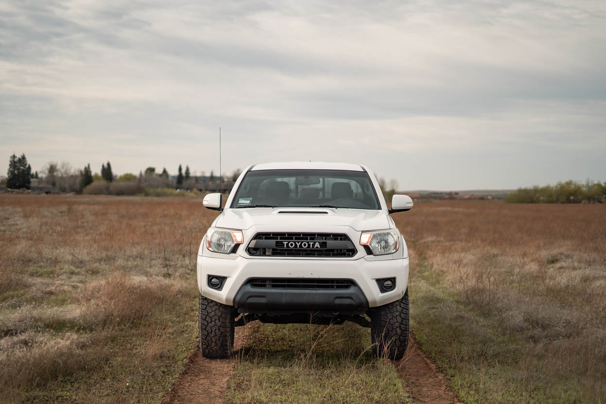 White Toyota Tacoma on a 3" Lift and 33" Yokohama Geolanders