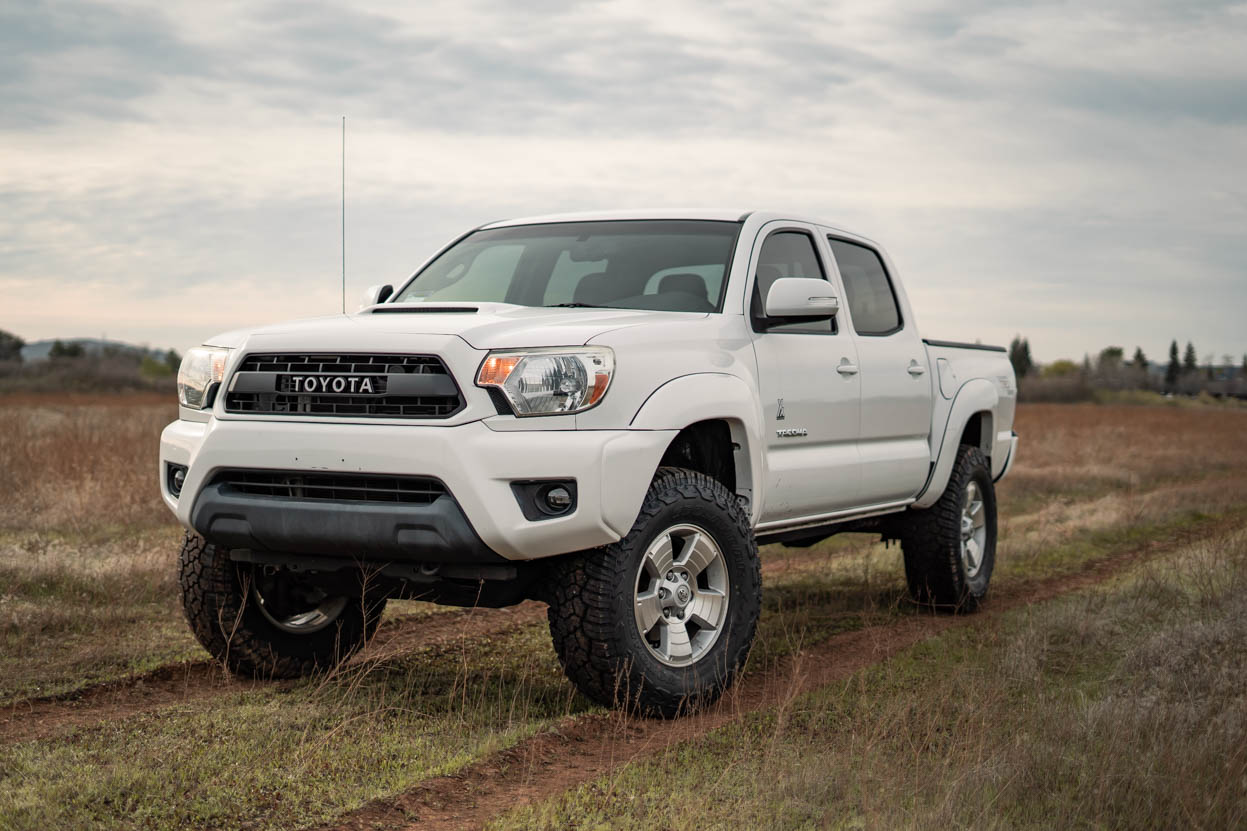 White Toyota Tacoma on a 3" Lift and 33" Yokohama Geolanders