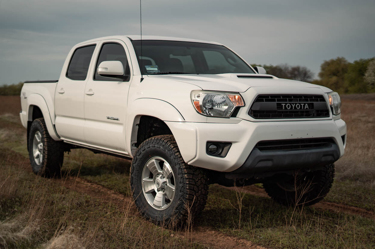 White Toyota Tacoma on a 3" Lift and 33" Yokohama Geolanders