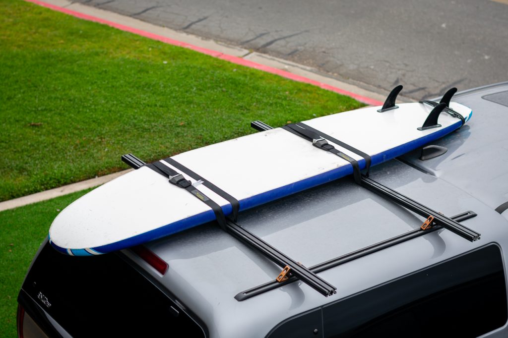 Surfboard Mounted to Custom Budget DIY Aluminum Roof Rack on Camper/Topper/Cap on 3rd Gen Tacoma