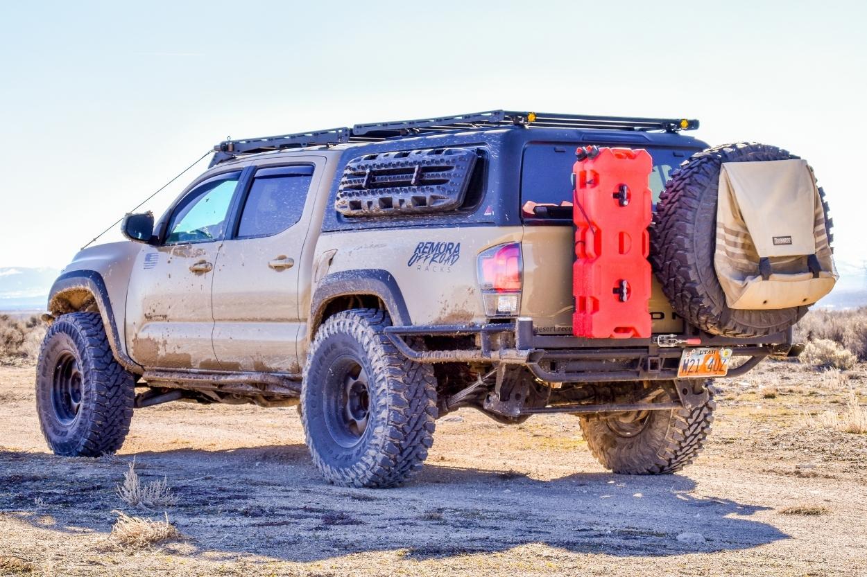 Long Travel Toyota Tacoma with Leer Truck Cap & High Clearance Rear Tube Bumper with Swing-Out