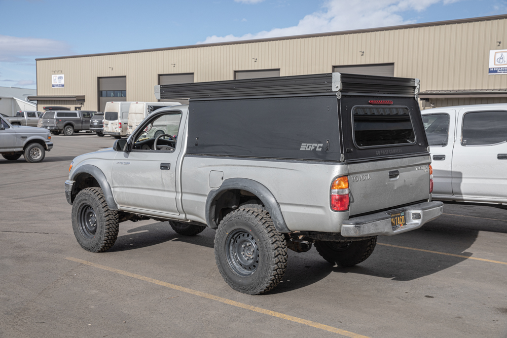 Lifted Silver 1st Gen Single Cab Tacoma with Black Go Fast Camper (GFC)