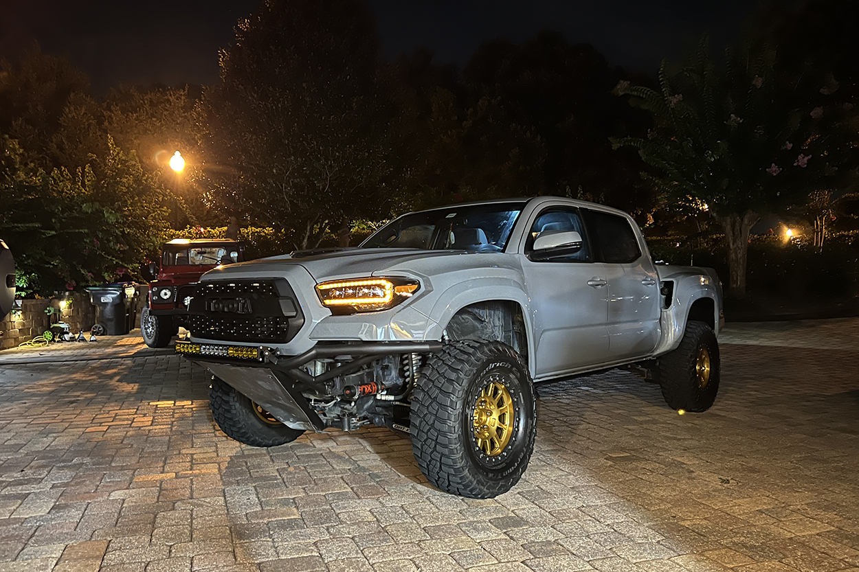 Cement Long Travel 3rd Gen Tacoma With Gold Wheels & BFG KM3 Mud-Terrain Tires