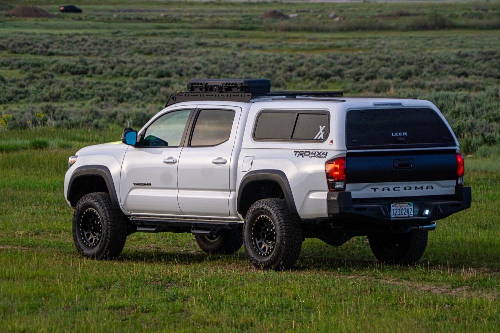 Leer Fiberglass Camper Shell With Sliding Side Windows Installed on 3rd Gen Super White Tacoma TRD Off-Road With All-Terrain Tires and Dirt Logic Lift Kit