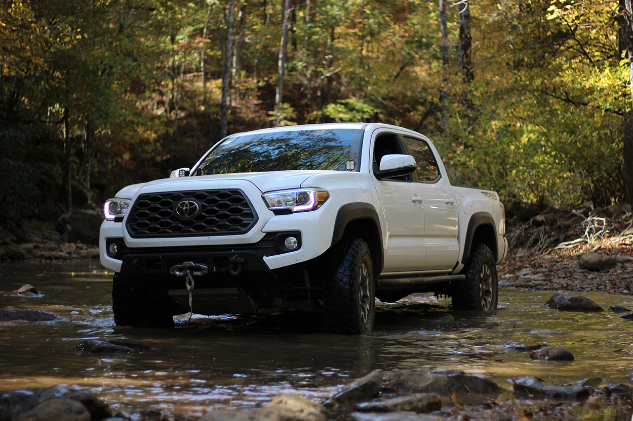 White TRD Off-Road Tacoma with Hefty Fab Rock Sliders