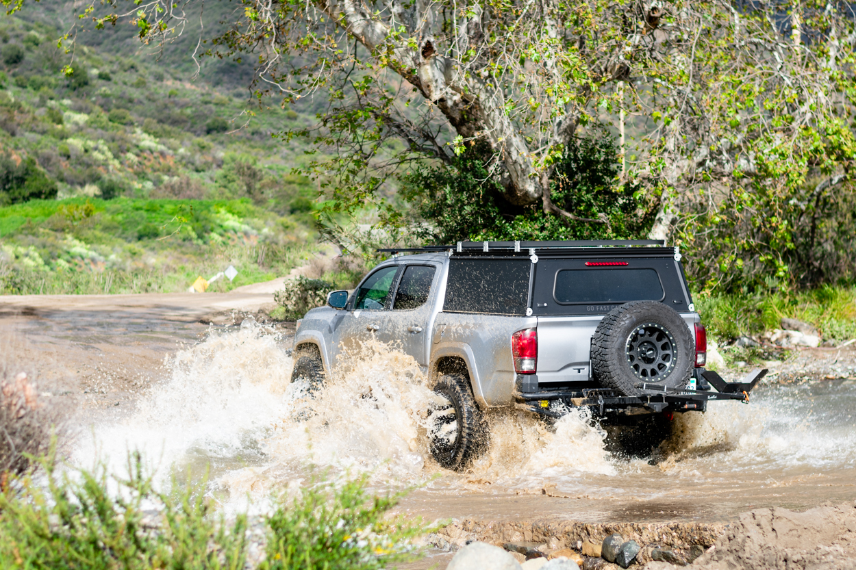 GFC (Go Fast Campers) Black Platform Utility Overland Camper Shell With Roof Rack Crossbars Installed on (2016+) 3rd Gen Tacoma Off-Road Build