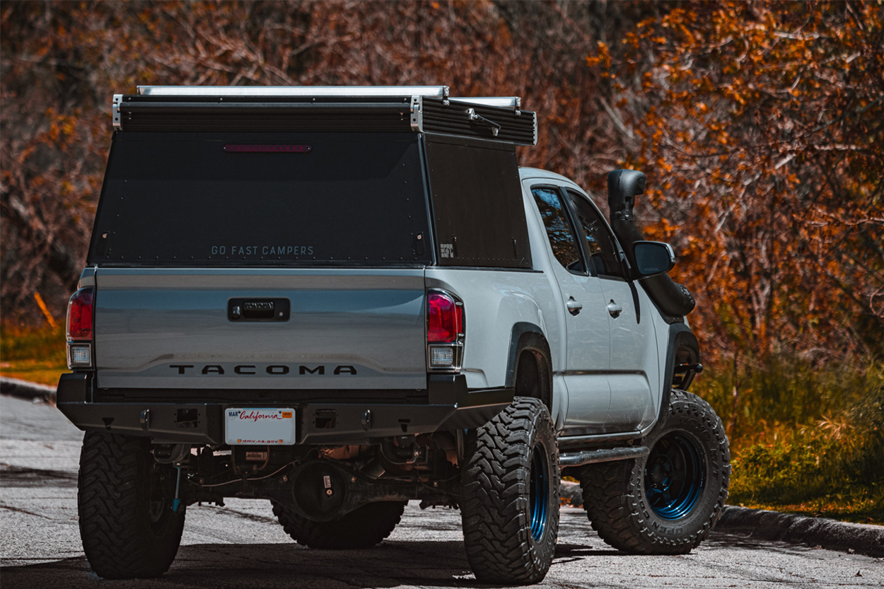 ATH Fabrication High Clearance Aftermarket Rear Bumper on Cement Grey 3rd Gen Tacoma with GFC Pop Up Camper, Off-Road Wheels and Mud Terrain Tires