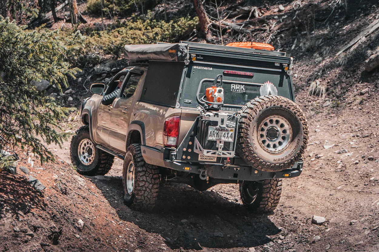 Backwoods Adventure Mods High Clearance Rear Bumper On Quicksand 3rd Gen (2016+) Tacoma with Go Fast Pop Up Camper, Full Size Spare Tire Carrier, Jerry Can Holder, and Mud Terrain Off-Road Tires