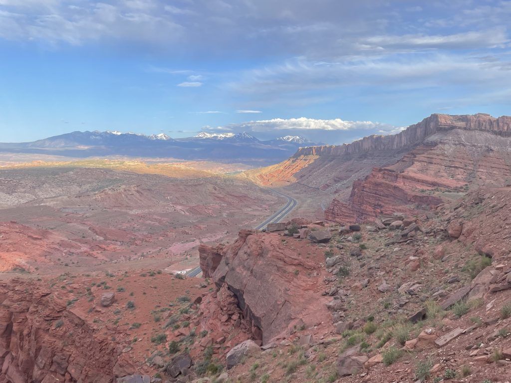 Vast view of La Sal Mountains and Moab Valley from Gemini Bridges 4x4 trail shelf road in Moab, Utah.