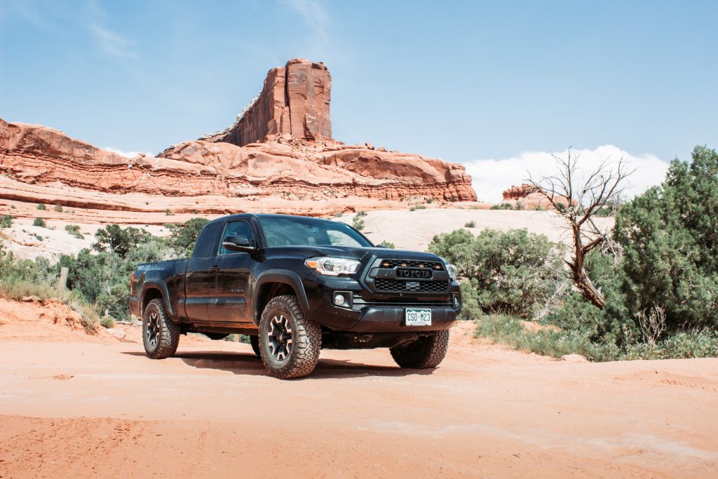 Black Toyota Tacoma TRD Off-road in front of desert mesa on Wipeout Hill Moab Alternate Route Moab off-roading trail