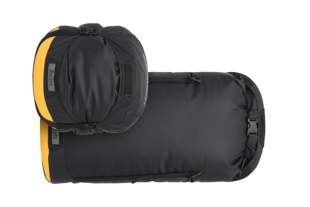 Overlanding accessories with a white background. Two sizes of Sea To Summit Evac Compression Dry Bag HDs in black and yellow colorways.