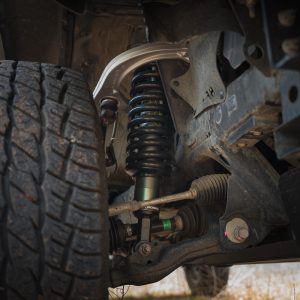 Front of Toyota Tacoma showing suspension with Ironman 4x4 IM2.5 front shocks and upper control arms with front tire.